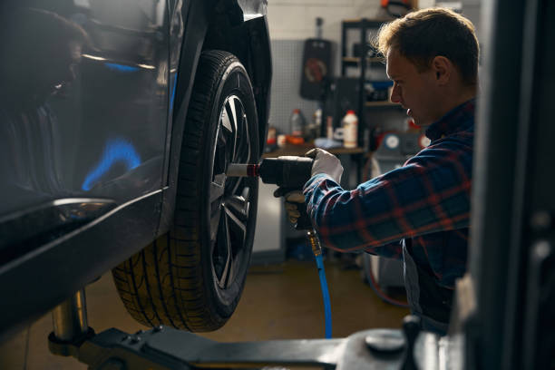 istock Mechanic in tire fitting doing automobile repair 2118278610