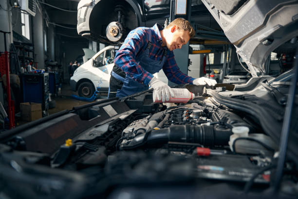 istock Young male adds coolant to cooling system 2118289605