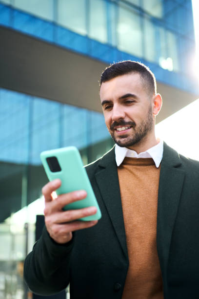 istock A young Caucasian man in a formal suit standing in front outside an office building 2118302414