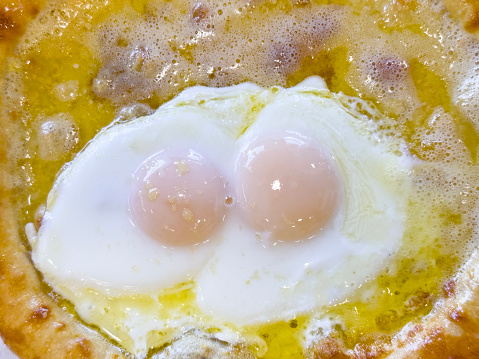 Looking down on a cheese pizza with delicious eggs
