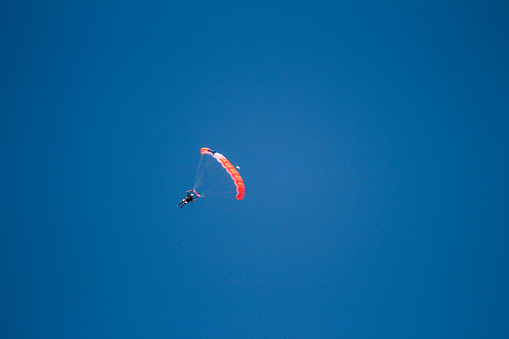 A skydiver with a red parachute in the air
