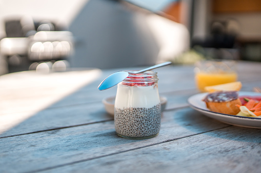 A close-up view of a nutritious breakfast consisting of chia seed pudding and fresh fruit, prepared on a wooden table at a serene vacation villa rental.