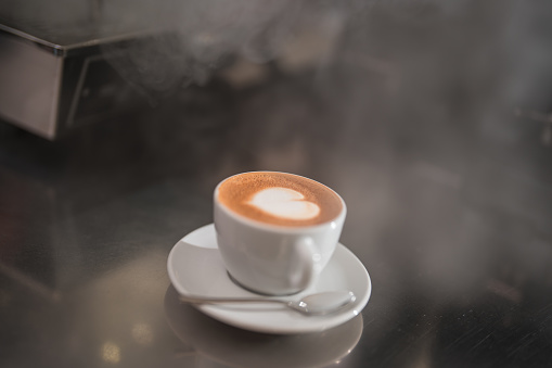The bar counter becomes a focal point of admiration with the exquisite latte art showcased on coffee cups, elevating the ambiance of the coffee house to a new level.