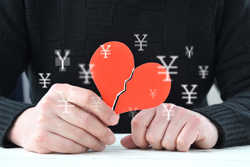Male hands and broken heart with Japanese yen mark appearing and disappearing at random