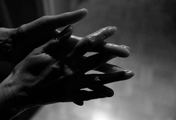 a master in black gloves holds bottles of henna for eyebrow coloring in front of him