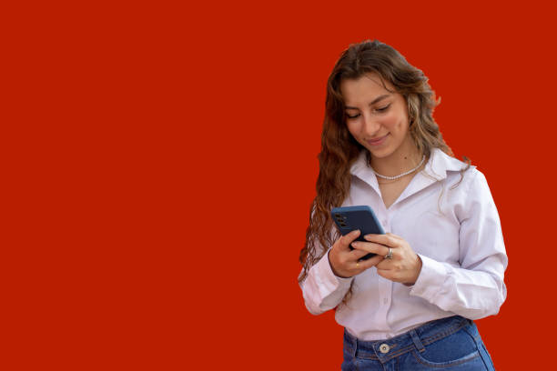 istock Beautiful young woman with cell phone and colorful background 2118619476