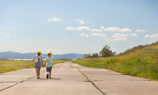 Sunny background with a boy and a girl walking forward