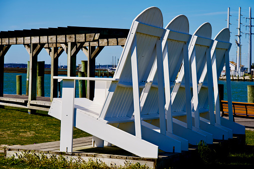 Chincoteague Island, Virginia, USA - March 21, 2024: Rear view of oversized wood chairs known as the “LOVE Chairs” in the Robert N. Reed Sr. Downtown Waterfront Park in the Town of Chincoteague.