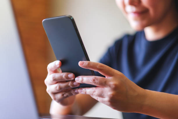 istock Closeup image of a young woman using smart phone and laptop computer 2118733494