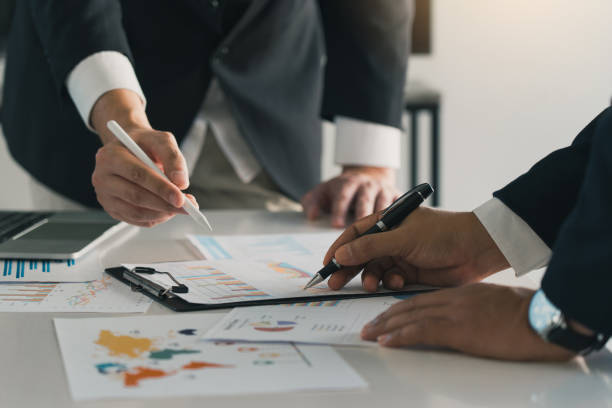 istock Two businessman team calculate about summary report annual on table office. 2118739475