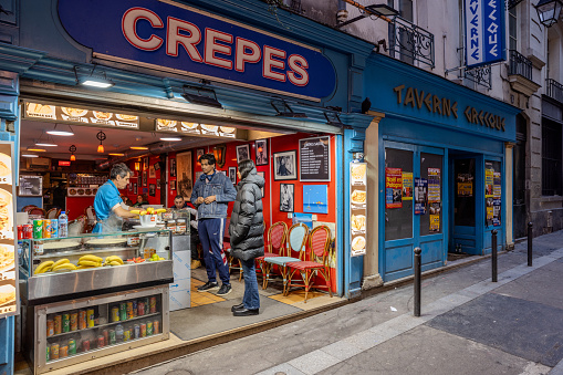Patrons waiting to be served in Crepes restaurant in Paris, France at Christmas night of 2023.
