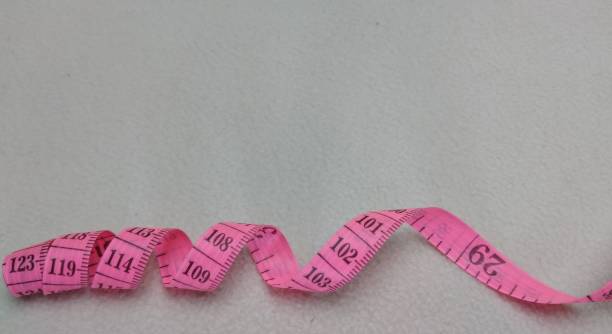 istock Pink measuring tape on a white background with copy space for text. 2118831782