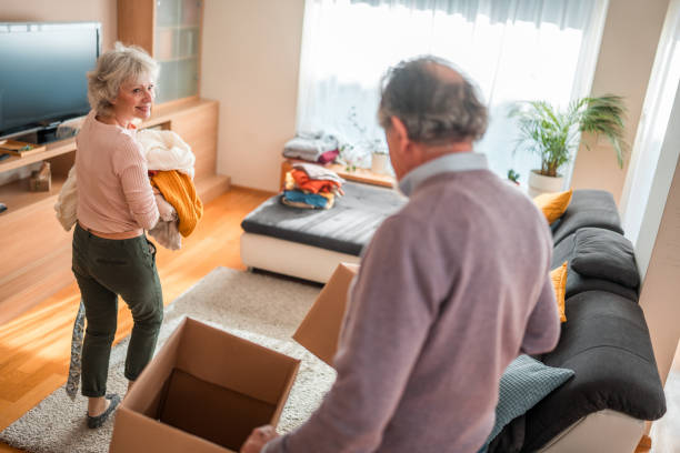 istock Senior Caucasian Couple Packing Clothes for Donation Indoor 2118900907