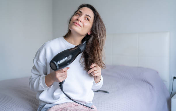 Woman Using Hair Dryer Woman Drying Her Hair With Hairdryer At Home woman hot shower stock pictures, royalty-free photos & images