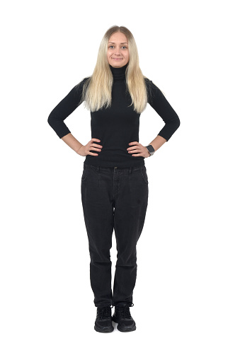 portrait of a blonde woman with arms akimbo standing on white background