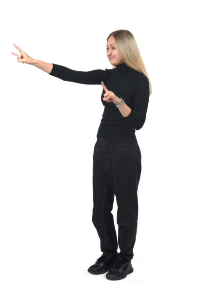 A young Asian woman is standing against a white background, wearing a light blue top, blue jeans, and black shoes. She has her arms raised above her head, with a smiling expression, appearing to be in a relaxed and active pose, showcasing a casual and healthy lifestyle.