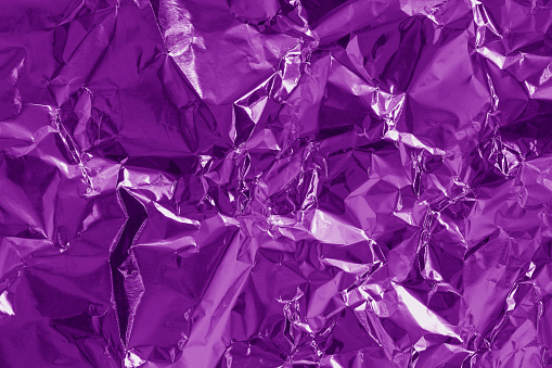 Shiny purple foil texture background, pattern of violet wrapping paper with crumpled and wavy.