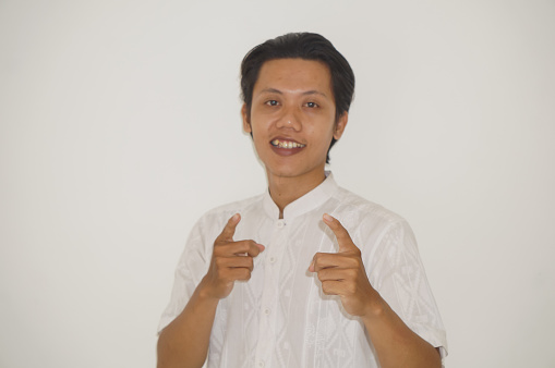 young asian man wearing white shirt happy and smiling by pointing at camera