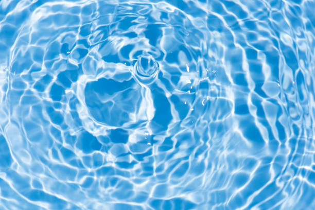 Blue water surface texture with ripples, splashes, and bubbles. Abstract summer banner background Water waves in sunlight with copy space cosmetic moisturizer micellar toner emulsion. Blue water wave.