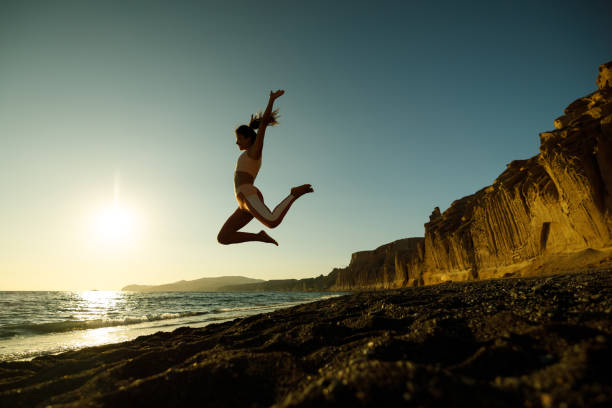 istock Happy woman jumping high up on the beach. 2119051214