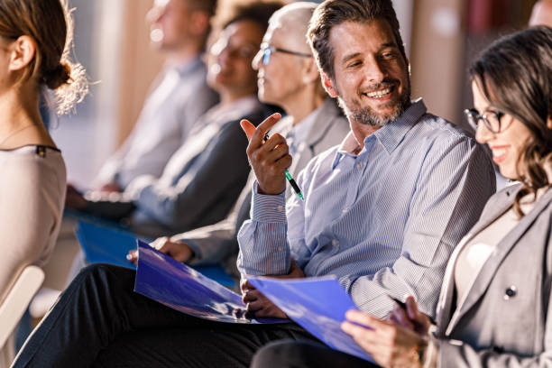 istock Happy business colleagues talking on education event in board room. 2119100145