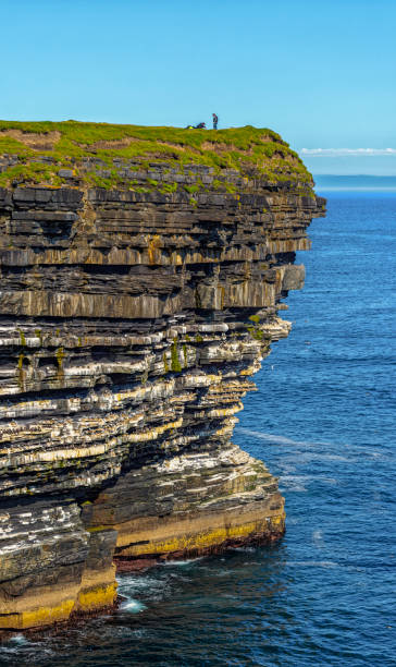 istock Fishing from the cliff - Cliff With Grassy Top Overlooking Water 2119102224