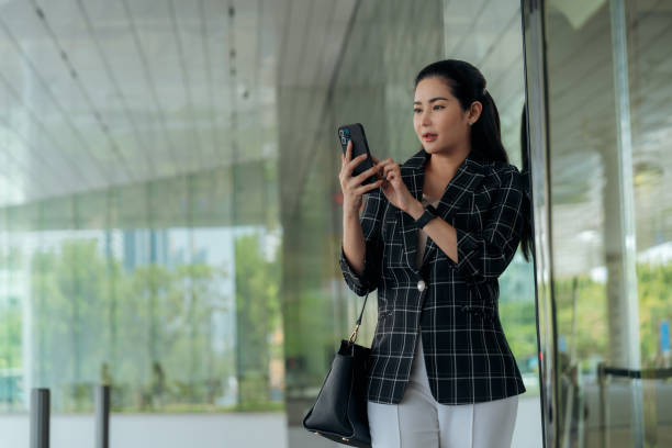 istock Female Retail audits using mobile phone while walking at business district 2119102726