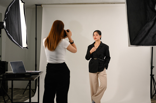 Beautiful young mode for professional photographer in photo studio.