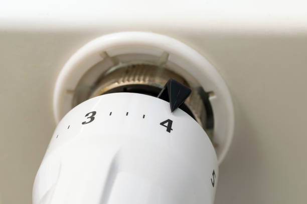 A white thermostat with the numbers 3, 4, 5 on it. The thermostat is set to 4