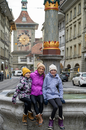 Family explores old town square in winter, Bern, Switzerland