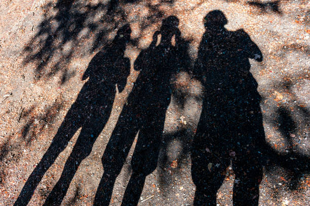 istock shadow of three people on the floor 2119119178