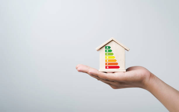 House energy efficiency, energy efficient rating class concept, eco home renovation save cost. Low-consumption ecological house. Hand holding Green Building for Sustainable Development Concept la eficiencia energética de la casa, el concepto de clase de clasificación de eficiencia energética, la renovación ecológica del hogar ahorran costos. casa ecológica de bajo consumo. de la mano del concepto de construcción ecológica para el desarro