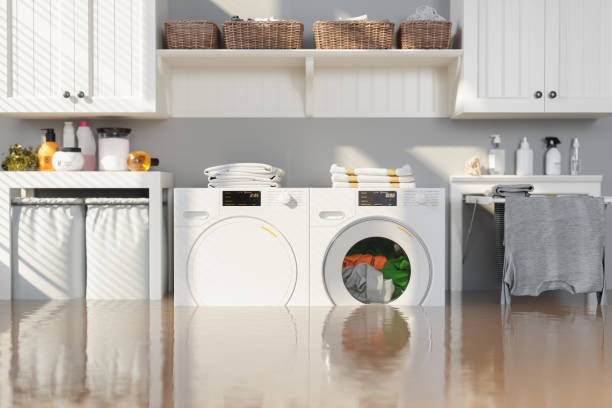 istock Flooded Laundry Room With Washing Machine, Dryer, White Cabinets and Drying Rack 2119140332