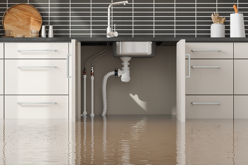 Flooded Kitchen With Front View Of Water Pipes Under Sink In Kitchen Cabinet