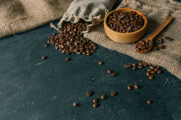 istock Coffee beans in a wooden plate on a black background 2119188719