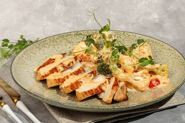 istock Grilled chicken breast sliced with stewed cauliflower and white sauce. 2119197048