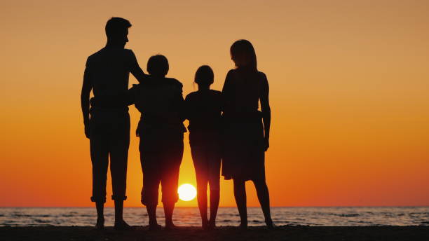 istock Happy multi-generational family enjoying sunset over the sea 2119201740