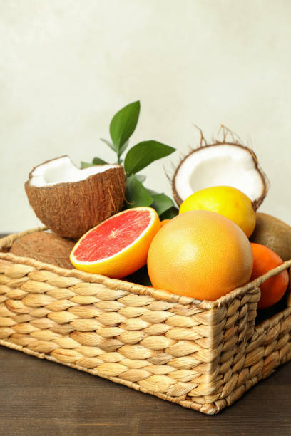 istock Basket with exotic fruits on wooden table 2119230456