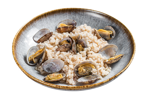 Italian Risotto with clams in a rustic plate with herbs.  Isolated on white background. Top view