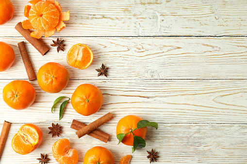 Mandarins and cinnamon on white wooden background