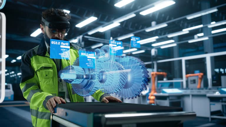 Automotive Factory Engineer Using Augmented Reality Headset in a Modern Facility with Automated Robotic Arms on an Assembly Plant. Specialist Ananlyzing and Manipulating a Virtual Gearbox Model