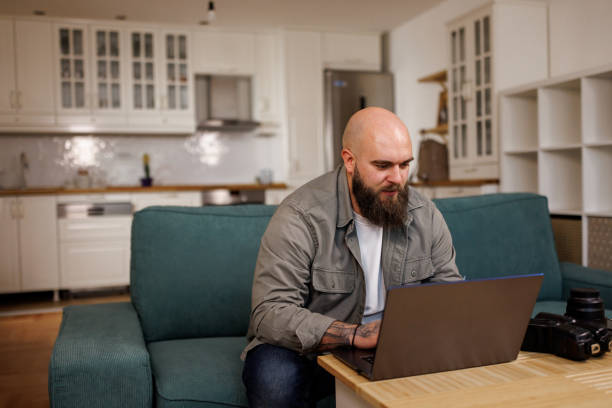 istock Young man using a laptop and credit card at home 2119274229