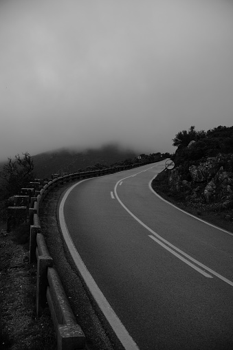 Black and white of mountain road on foggy natural landscape