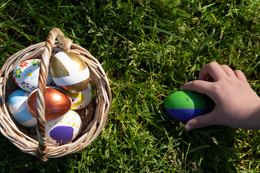 Colorful Easter eggs in little girls hand.Kids hunt for egg outdoors