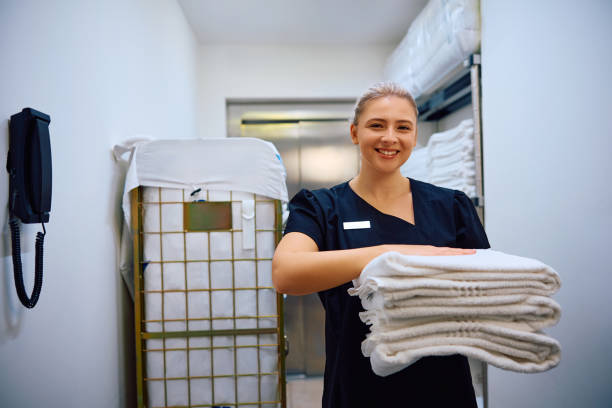 istock Happy hotel maid with clean towels looking at camera. 2119345432