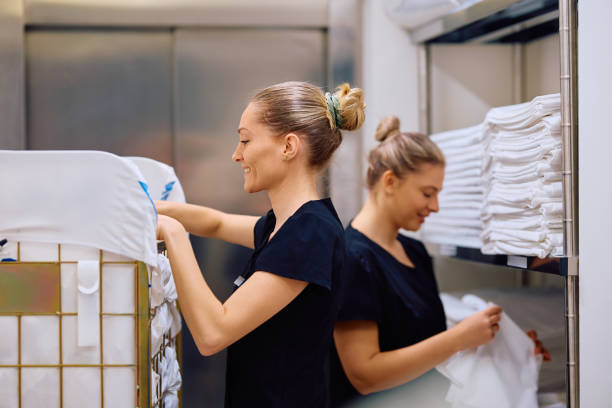 istock Happy maids working in hotel laundry room. 2119345985
