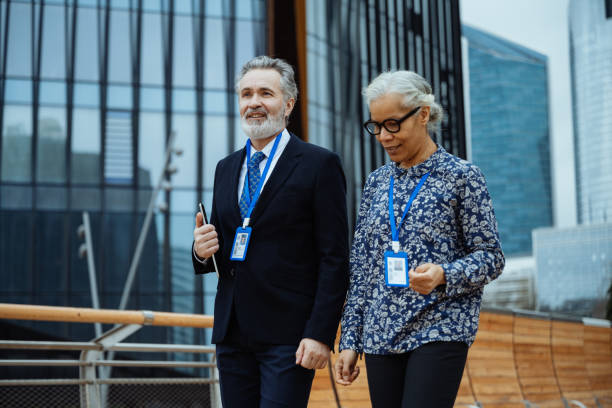 istock Mature diverse business people in financial district. Diverse senior employees using digital tablet and discussing business 2119346408