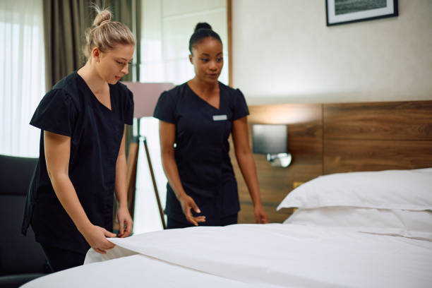 istock Young maids cooperating while cleaning hotel room. 2119376952