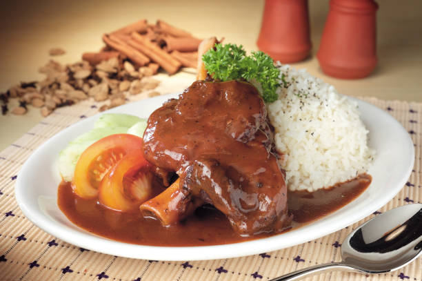 istock Braised lamb shank served with vegetables and rice 2119409564