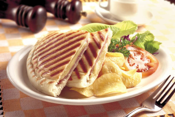 Grilled and pressed toast with smoked ham, cheese, potato chips and salad